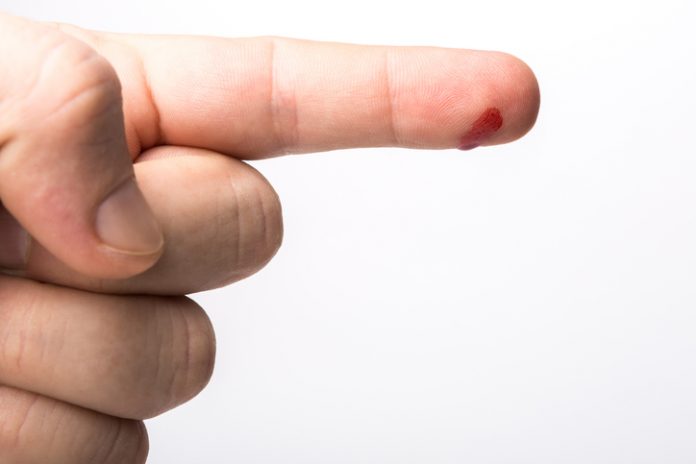 Finger with drop of fresh blood