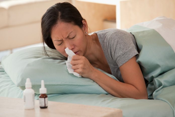 Asian woman in bed with the flu