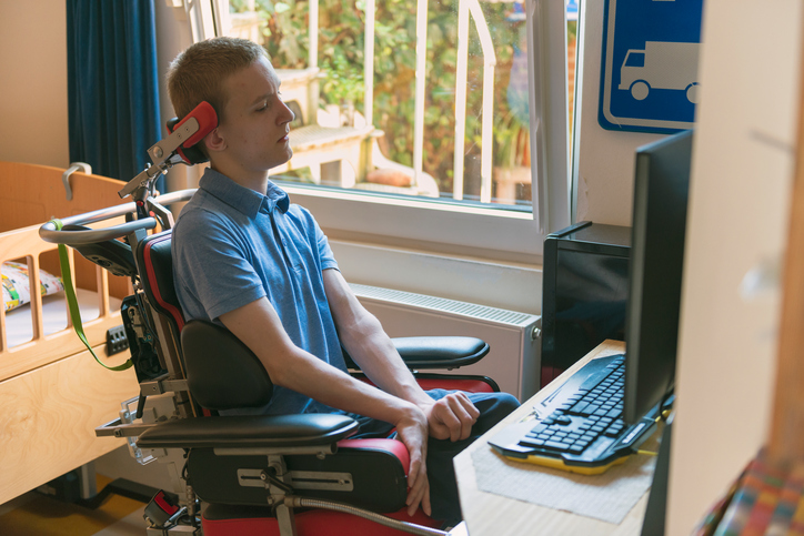 Young disabled man playing computer game