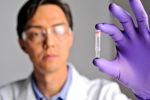 A Thermo Fisher scientist hold an NGS sample vial.