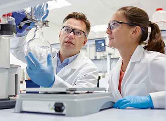 Scientists using rotary evaporator in laboratory