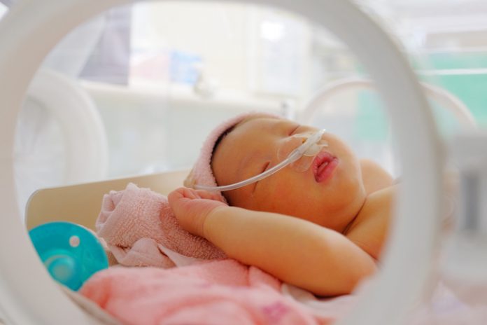 Sleeping newborn in hospital bed