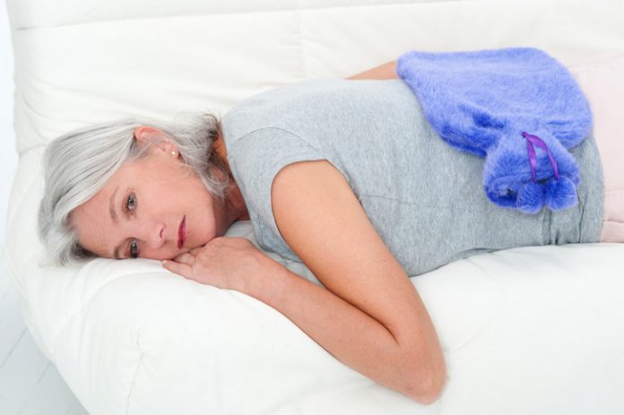 Woman lying down with hot water bottle