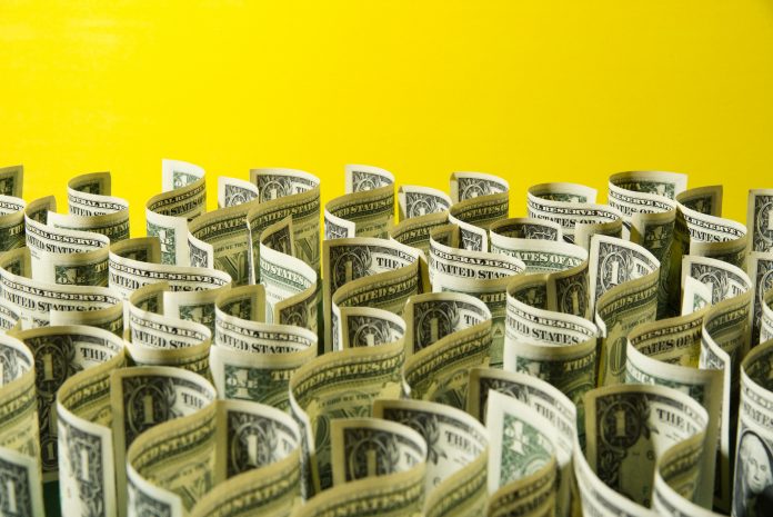 Sea of US 1 dollar bills on yellow background