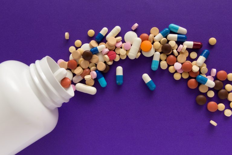 Medicines With Bottle On Purple Background