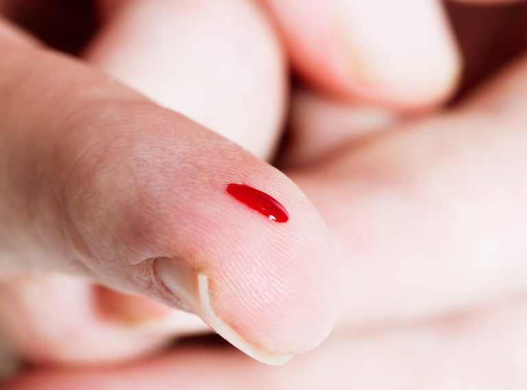 Close up on drop of blood at finger tip