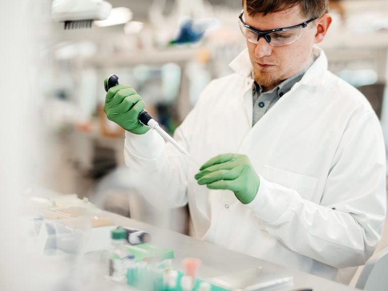 male scientist pipettes in lab