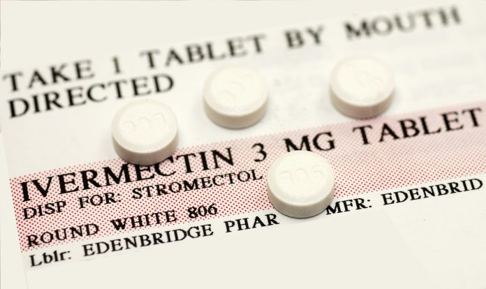 Ivermectin pills (a broad-spectrum antiparasitic agent) on top of instruction label. This medication is a common therapy against parasitic worms such as helminths