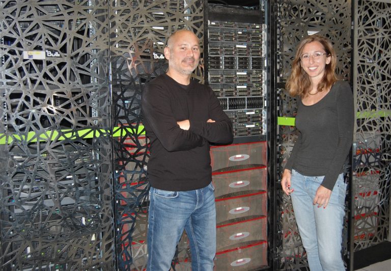 Sergi Beltran and Leslie Matalonga pictured in front of a supercomputer and servers that hosts the RD-Connect Genome-Phenome Analysis Platform. The platform is located at the Centro Nacional de Análisis Genómico - Centre for Genomic Regulation facilities in the Parc Cientific de Barcelona