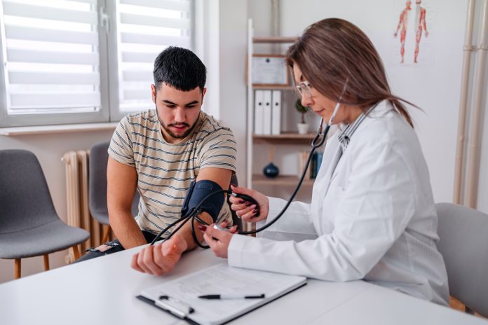 Doctor Measuring Blood Pressure Of A Young Patient with type 1 diabetes to assess benefits of bromocriptine