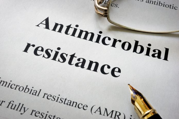 Paper with words antimicrobial resistance AMR and glasses.