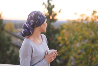 woman looking at mountains with headscarf and a cup in her hand