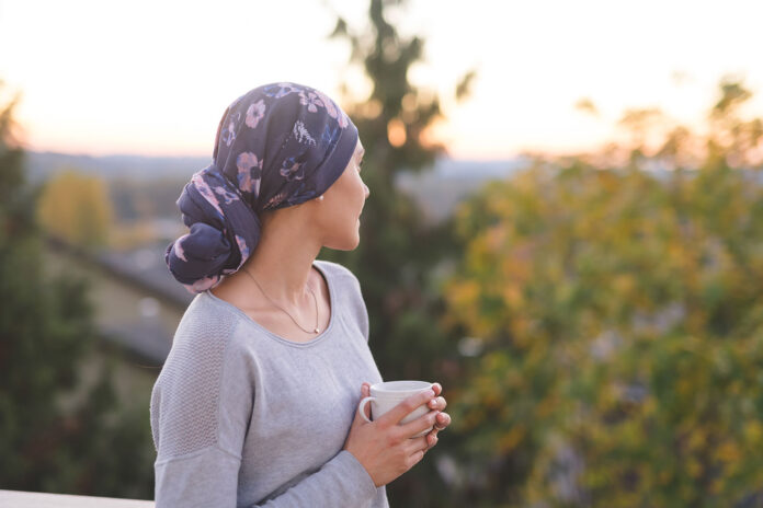woman looking at mountains with headscarf and a cup in her hand
