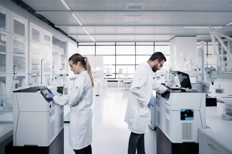 Picture of a male and female scientist working in a lab using the MAGNA one machine to visualize RNA
