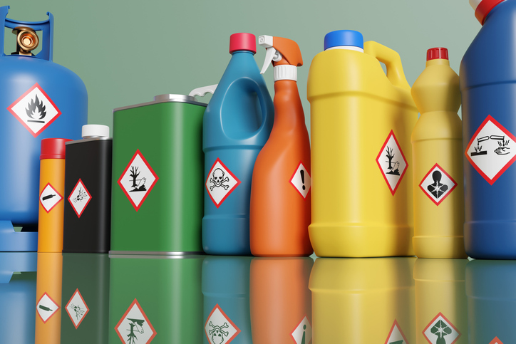 Plastic bottles and metallic tins having with different hazardous warning labels. forever chemicals