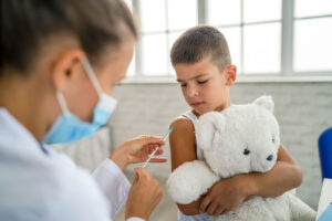 Young boy receiving and injection from Pediatrician
