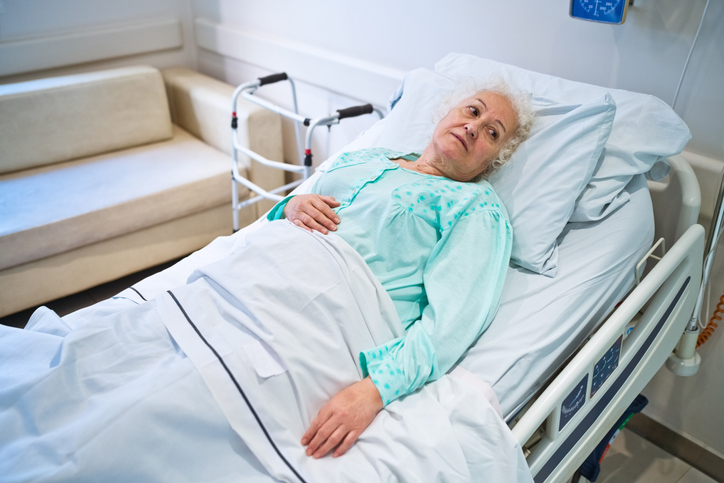 Older female patient lying in hospital bed to represent misdiagnosis of community-acquired pneumonia