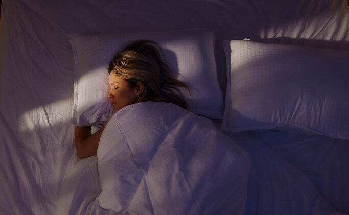 Above view of relaxed woman sleeping in bed at night.