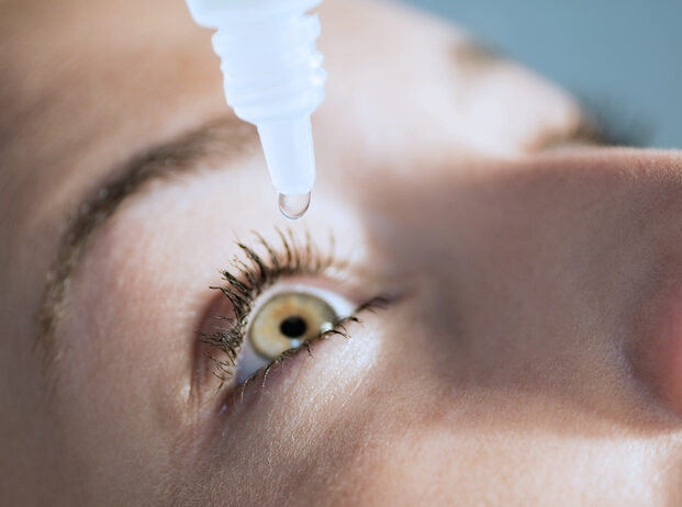 483720785 Eyedropper releasing fluid into an eye